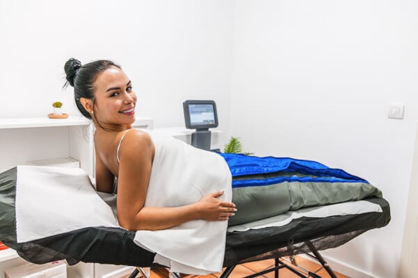 femme réalisant un traitement de pressothérapie dans un institut de beauté