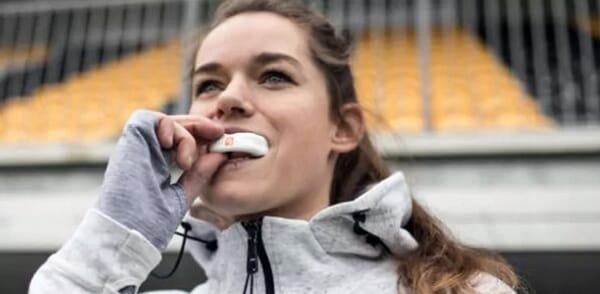 femme-sportive-mettant-son-protege-dents-mouthguard