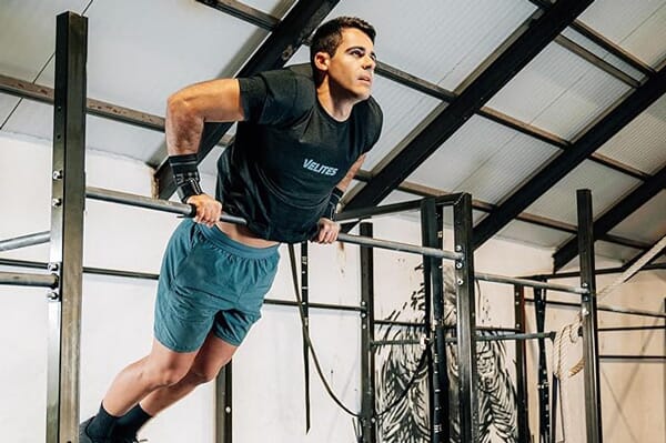 Homme faisant un Muscle up avec maniques Velites All terrain